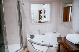 uma casa de banho branca com uma banheira e um chuveiro em Apartamenty Gala em Sułkowice