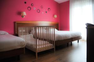 a bedroom with two beds and a pink wall at Hotel Marco Effe in Mestrino