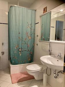 a bathroom with a shower curtain and a toilet and a sink at Traumhafte Wohnung im Herzen von Leipzig in Leipzig