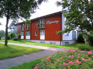 a red and white building with flowers in front of it at Hotel Rappensberg garni in Bad Birnbach