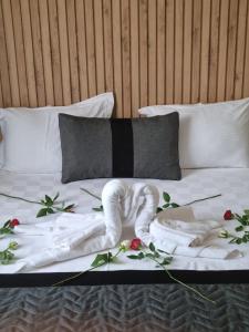 a bed with a white robe and flowers on it at LEONS HOTEL in Canakkale