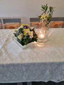 una mesa con un jarrón de flores y una vela en LEONS HOTEL, en Canakkale