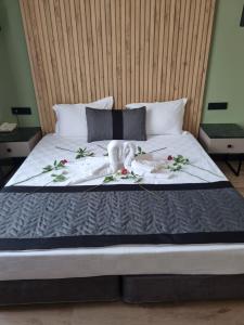 a bed with a white blanket and flowers on it at LEONS HOTEL in Canakkale
