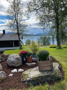 a garden with rocks and potted plants and a lake at Great house with amazing location!!Sea & mountain view! in Kvaløya