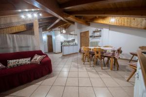 a living room with a table and a red couch at appartamento val di sole in Dimaro