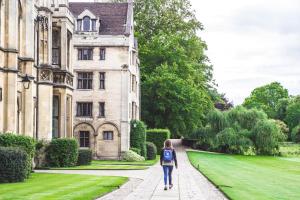 a woman walking down a path in front of a building at Ditton Fields by condokeeper in Chesterton