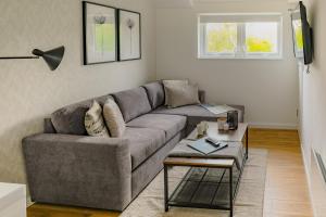 a living room with a gray couch and a table at Ditton Fields by condokeeper in Chesterton