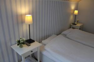 a bedroom with a bed and a table with a lamp at Hotel Stallbacken Nagu in Nauvo