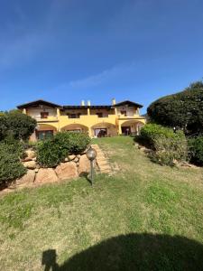 a large yellow house sitting on top of a grass field at La casa del sole in Chia