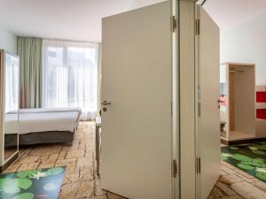 1 dormitorio con 1 cama y puerta corredera en ibis Styles Karlsruhe Ettlingen, en Ettlingen