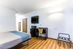 a bedroom with a bed and a desk and a tv at Motel 6-Indianapolis, IN - Southport in Indianapolis