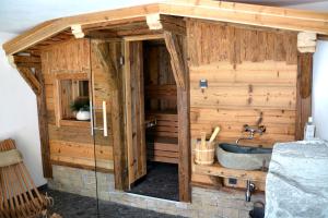 La salle de bains en bois est pourvue d'une baignoire et d'un lavabo. dans l'établissement Chalet Grossglockner, à Fusch an der Glocknerstraße