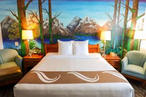 - une chambre avec un lit et une peinture de montagnes dans l'établissement Quality Inn & Suites Sequim at Olympic National Park, à Sequim