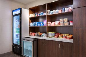a kitchen with a refrigerator and shelves with food at Comfort Inn & Suites Gaylord in Gaylord