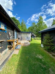 a backyard with a wooden deck next to a house at StugaNäraKungsberget - mysig stuga med kamin, grillkåta och vedbastu in Ockelbo