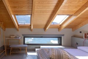 Schlafzimmer mit Holzdecken, einem Bett und einem Fenster in der Unterkunft Evia Silence in Boufalo