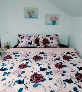 - un lit avec une couette à fleurs dans l'établissement Vila Roxana, à Pangarati