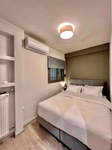 a bedroom with a large white bed and a fan at Lovely 1-Bedroom 2 minutes from Beach in Athens