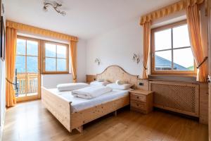 a bedroom with a bed and two windows at Gruberhof Coll in Funes