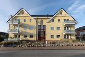 een geel appartementencomplex met twee verdiepingen bij Lighthouse 7 in Grömitz