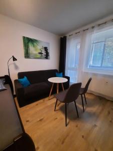 a living room with a black couch and a table at Apartment Klimka with balcony and free parking in Bratislava