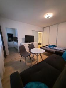 a living room with a couch and a table and a bed at Apartment Klimka with balcony and free parking in Bratislava