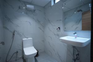 偉傑瓦拉的住宿－Eden Park Boutique Hotel，白色的浴室设有卫生间和水槽。