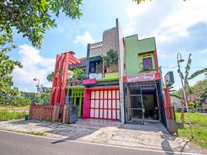 um edifício colorido no lado de uma rua em Capital O 91690 Moza Guest House em Klaten