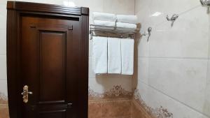 a bathroom with a towel rack with towels at Villa Oasis in Bukhara