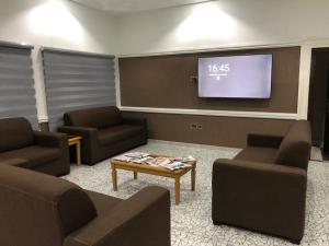 a waiting room with couches and a flat screen tv at Yakam Hotel Limited in Kintampo