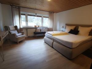 1 dormitorio con cama, silla y ventana en Zur Mühle, en Mörlenbach