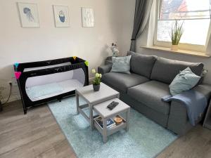 sala de estar con sofá y cama en Ferienwohnung „Deichgeflüster“ nahe der Nordsee, en Marne