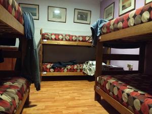 Pokój z 3 łóżkami piętrowymi i drewnianą podłogą w obiekcie Hostal El Caracol w mieście Valdemoro