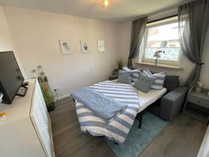 een kleine slaapkamer met een bed en een bank bij Ferienwohnung „Deichgeflüster“ nahe der Nordsee in Marne