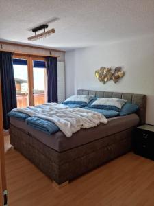 a bedroom with a large bed with blue pillows at Gemütliche Ferienwohnung zwischen See und Bergen in Brienz