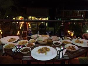a wooden table with plates of food on it at Jade Green Rest Inn in Ella