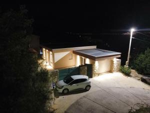 a car parked in front of a house at night at Casa M Montenegro in Donji Morinj