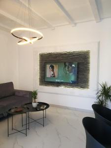 a living room with a couch and a tv on a wall at Casa M Montenegro in Donji Morinj