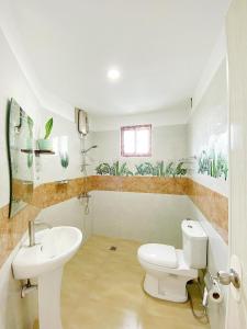 een badkamer met een wit toilet en een wastafel bij Kabansoy Haven in Moalboal
