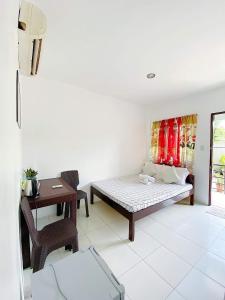 een slaapkamer met een bed, een bureau en een tafel bij Kabansoy Haven in Moalboal