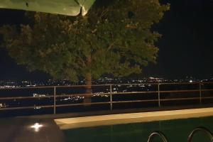 een boom die 's nachts op een balkon staat bij Moderne Villa mit atemberaubendem Seeblick in Lisciano Niccone