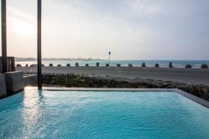 a swimming pool with the ocean in the background at Aqua Beautique Poolvilla in Jeju