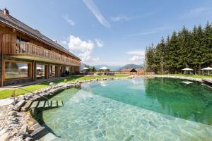 a large swimming pool in front of a building at Lerchpeuntgut Almchalets in Tamsweg