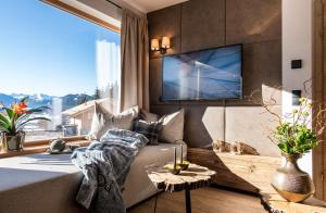 a living room with a couch and a large window at Lerchpeuntgut Alpenfreud Chalets in Tamsweg