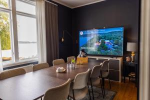 a dining room with a table and a large screen tv at Surfviken Glamping and B&B in Stenungsund