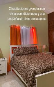 a bedroom with a bed with an orange curtain at Villa Victoria in La Romana