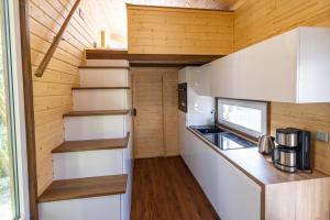 a kitchen in a tiny house with wooden walls at Tiny Haus - Im Herzen vom Unterallgäu in Erkheim