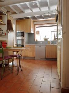 a kitchen with a table and chairs and a window at Charming stone villa with pool & garden in Montaren-et-Saint-Médiers +3 photos