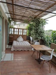 a patio with a bed and a table and chairs at Charming stone villa with pool & garden in Montaren-et-Saint-Médiers