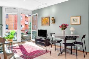 a living room with a table and chairs and a tv at Keybutler Central Apartment Grønland in Oslo